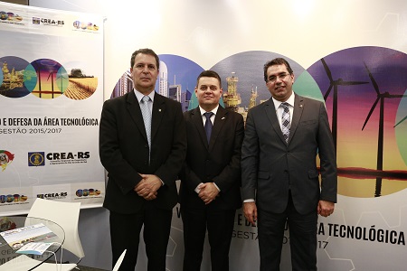 Eng. Alexandre (centro), Senge, recepcionado no estande do CREA-RS pelo Eng. Melvis Barrios Junior (esq.) e Eng. Fernando Martins (dir.), presidente e 1º vice-presidente CREA-RS