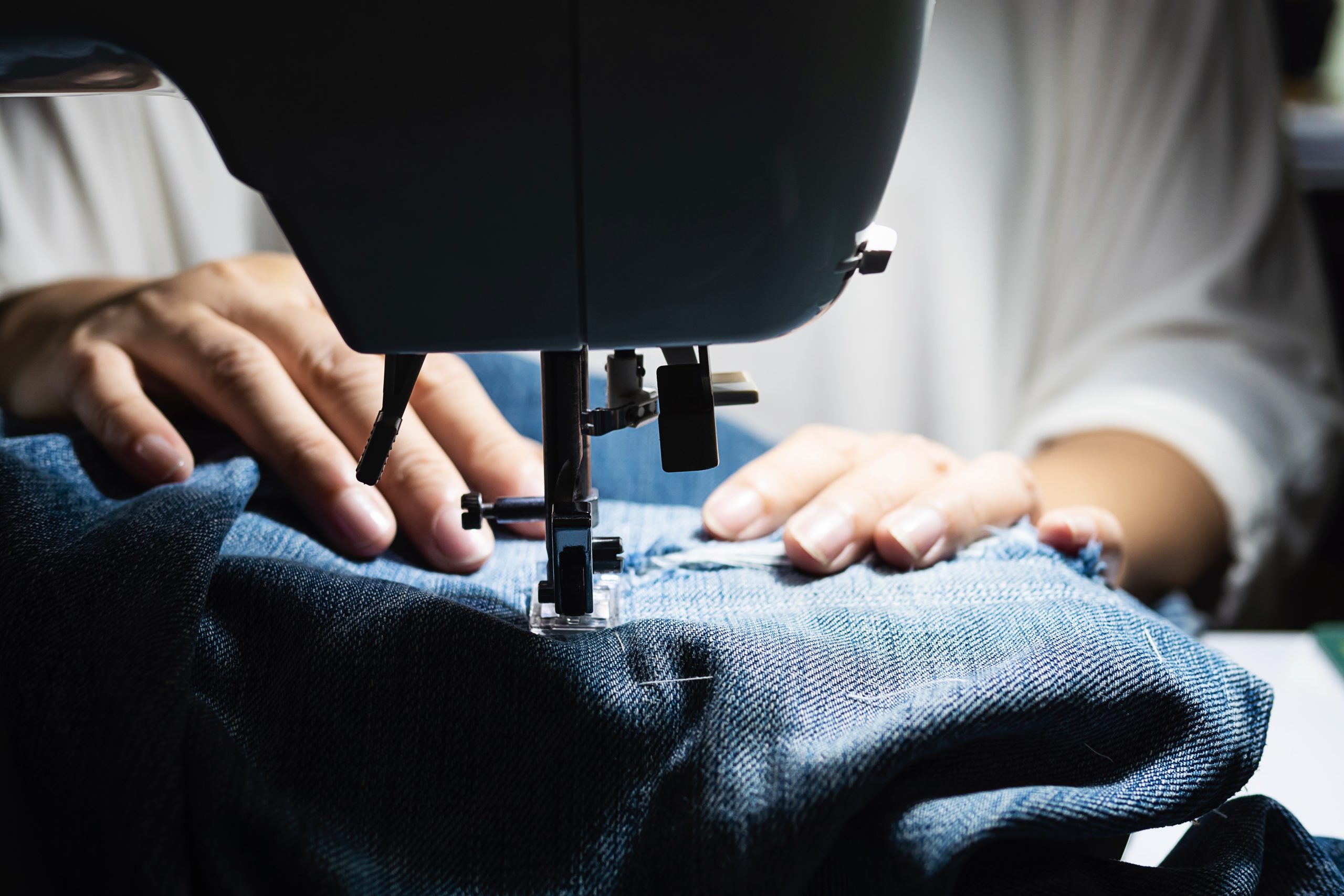 woman-doing-jeans-patchwork-using-sewing-machine-home-diy-sewing-concept.jpg